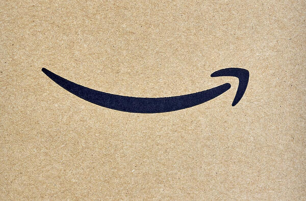 Closeup of an Amazon delivery box with the black curved arrow logo prominent