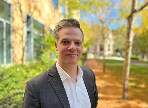 Alex Coppock in a courtyard outside his office