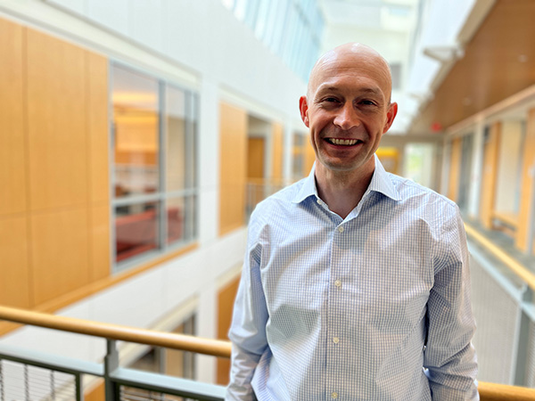 Milan Svolik stands in the atrium outside his office