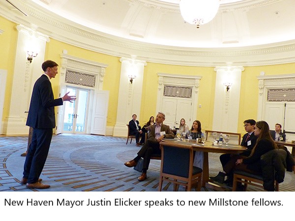 Justin Elicker speaks to students, faculty, and alumni in a round room.