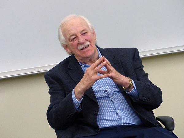 Bruce Morrison speaks in a classroom while seated