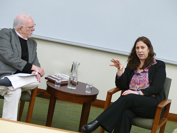 Stephen Skowronek and Colleen Shogan speak while seated on either side of a small table in a classroom