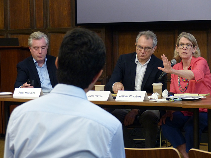 Simone Chambers fields a question while seated at a table next to Mark Warren and Peter MacLeod