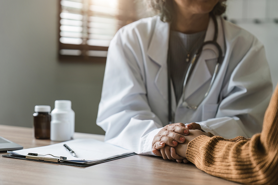 Close up doctor holding a patient's hand at medical visit