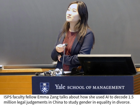 Emma Zang speaks from a lectern in a circular classroom