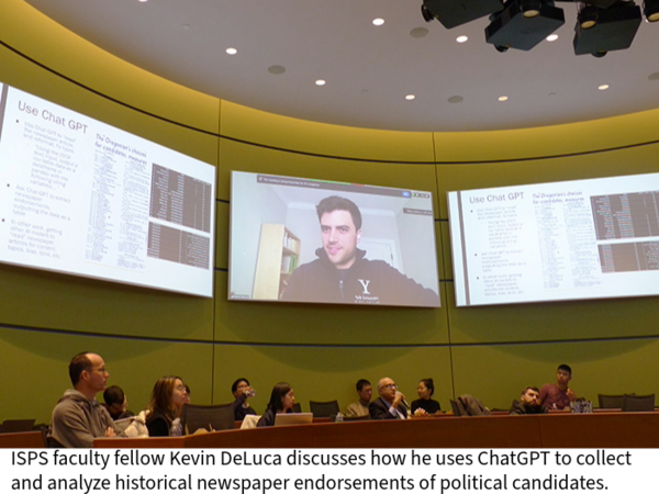 Attendees of a session in a circular classroom listen to Kevin DeLuca speak from one of several large screens high on the walls.