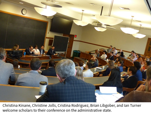 Participants in a conference listen to the organizers in a large law school classroom