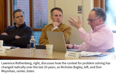 At a table in a classroom, Lawrence Rothenberg, right, discusses how the context for problem solving has changed radically over the last 20 years, as Nicholas Bagley, left, and Don Moynihan, center, listen.