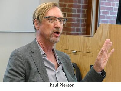 Paul Pierson speaks seated at a table in a classroom