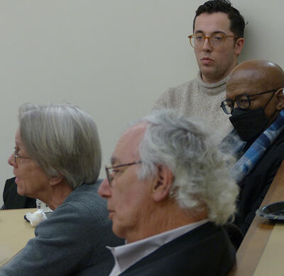 faculty members participate in a panel discussion seated in the audience
