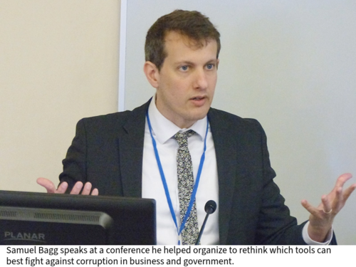Samuel Bagg speaks behind a lectern in a classroom