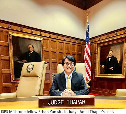 Ethan Yan sits in the seat of U.S. Court of Appeals Judge Amal Thapar with portraits and a flag in the background