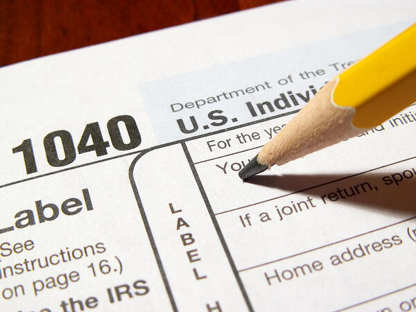 Closeup of a pencil filling out a 1040 tax form