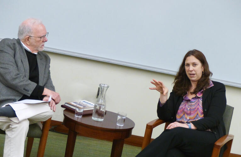 Stephen Skowronek and Colleen Shogan speak while seated with a small table between them in a classroom