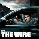 Advertisement for "The Wire" TV show with police officers in a car looking at the leaders of a drug organization, reflected in the window