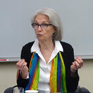 Kathleen Thelen speaks from a conference table in a classroom.
